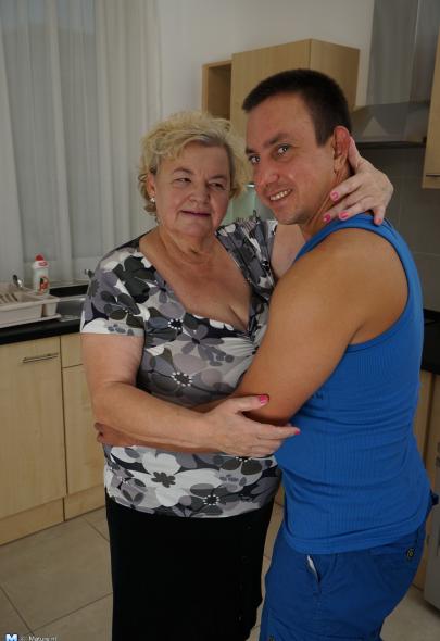Curvy granny having fun with her toy boy in the kitchen.