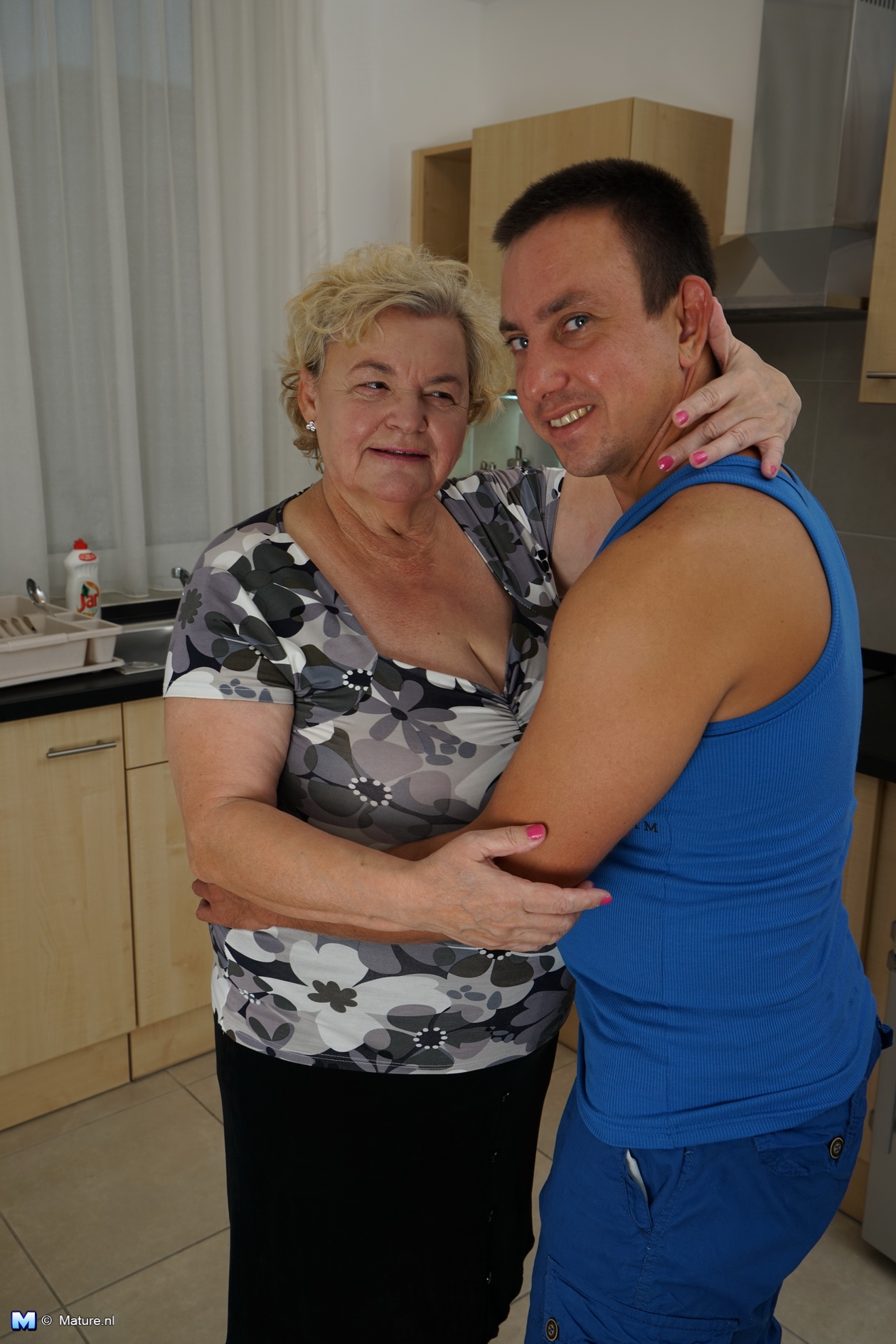 Curvy granny having fun with her toy boy in the kitchen